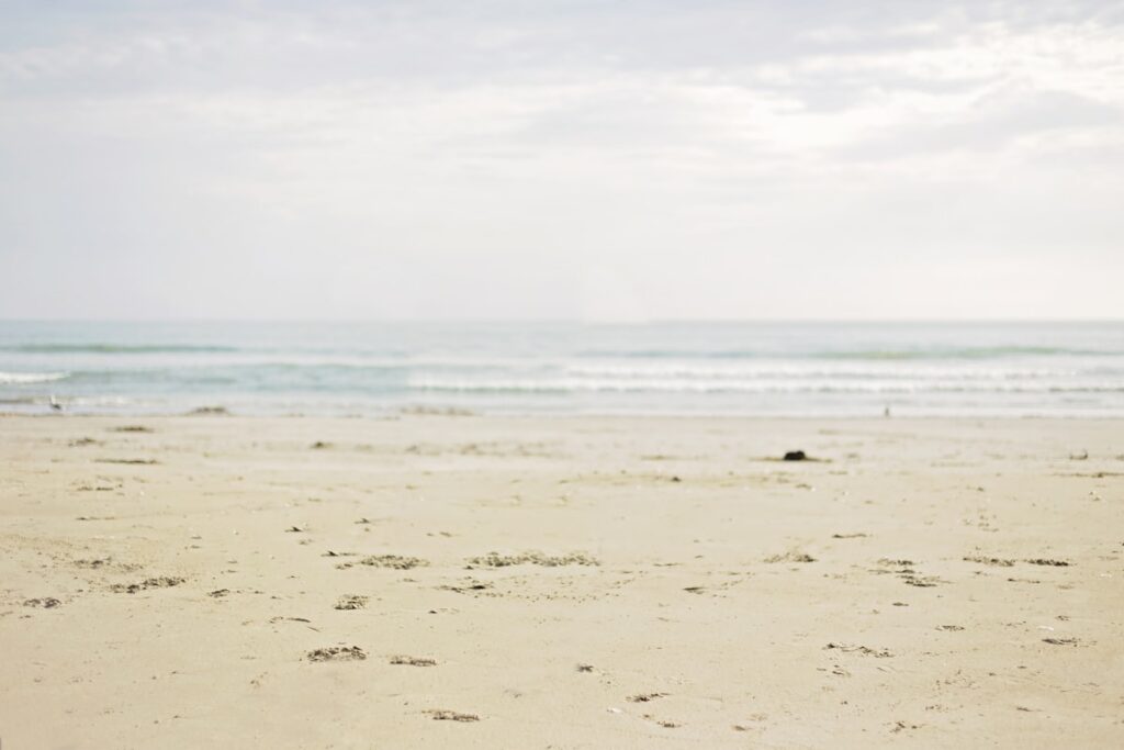 Calm sandy beach with gentle ocean waves at a budget-friendly US beach destination
