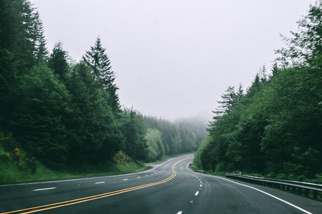 Scenic two-lane highway cutting through open countryside on a road trip