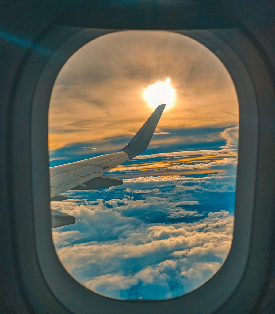 View from airplane window showing clouds and engine during a domestic flight