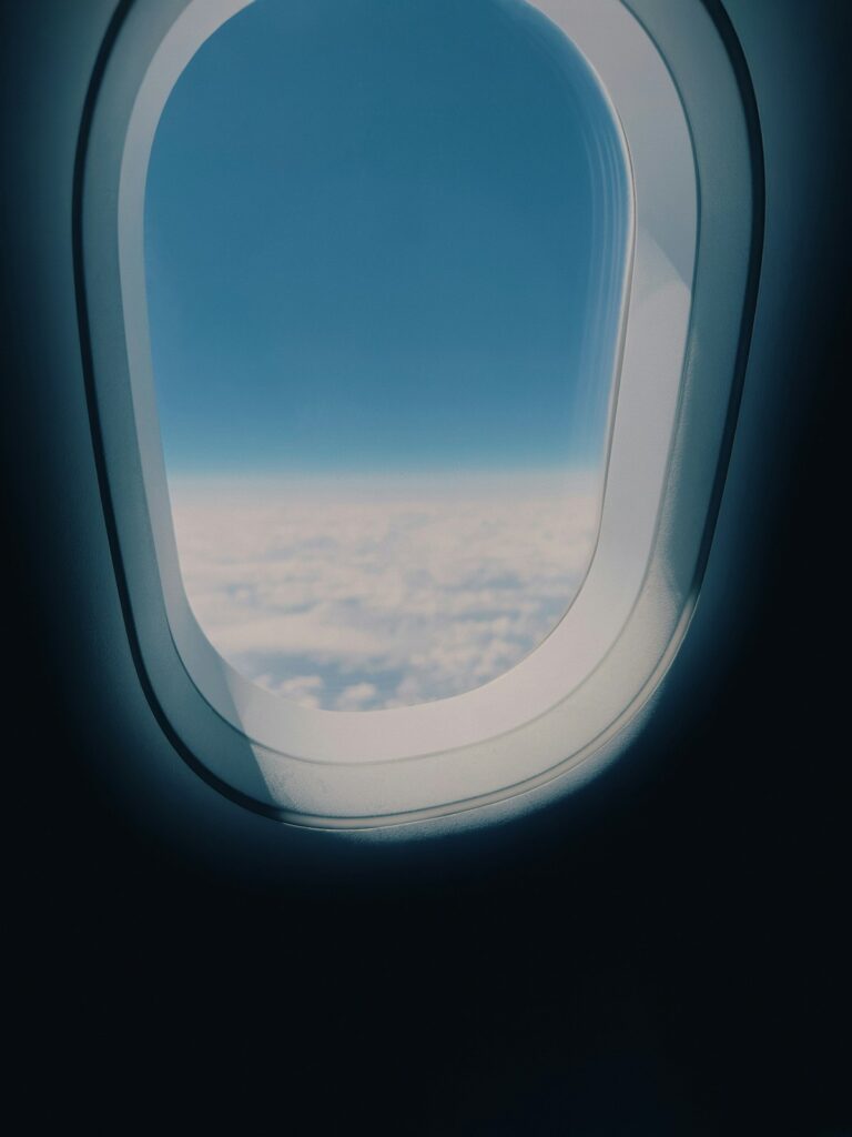 View from airplane window showing blue sky and clouds