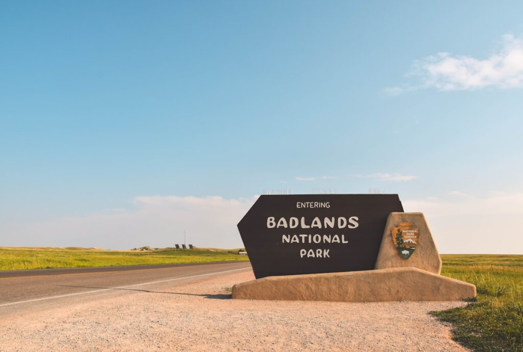 Badlands National Park entrance sign beside a road