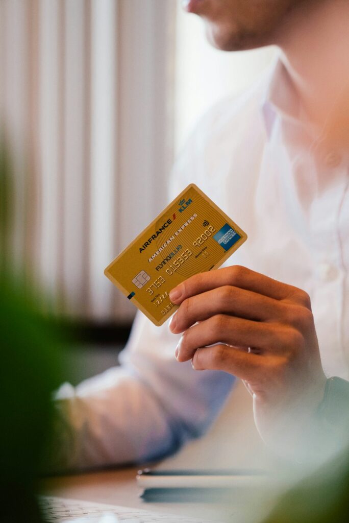 Person holding a gold travel rewards credit card