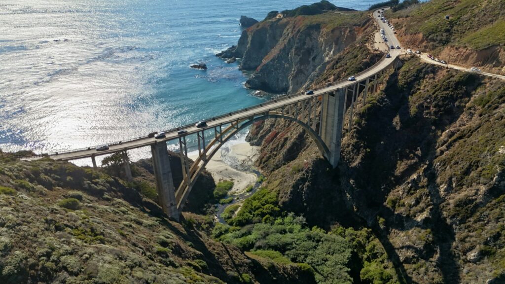 Pacific Coast Highway on a budget: aerial view of Bixby Creek Bridge in Big Sur with the Pacific Ocean