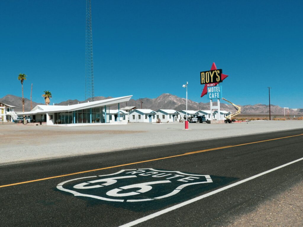 Cost to do Route 66: vintage Route 66 shield sign on the side of a desert road