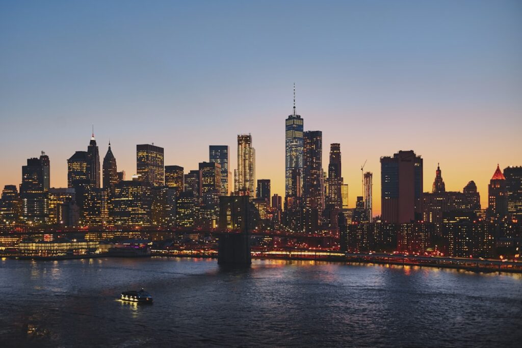 New York City on a budget: Brooklyn Bridge and Lower Manhattan skyline at dusk